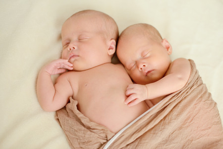 sweet twins are sleeping and hugging in soft focusの写真素材