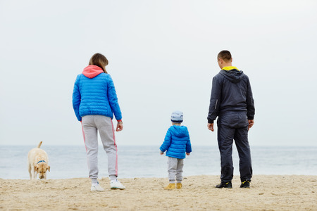 family walking near the sea with dogの写真素材