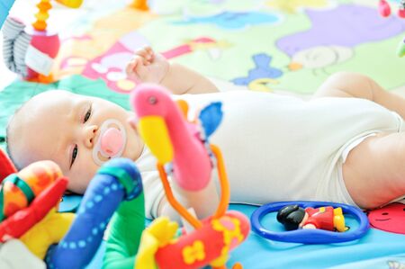 little baby on the carpet with toys