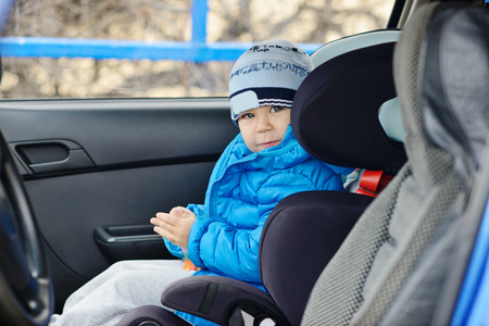 happy toddler boy sitting in the car seatの写真素材