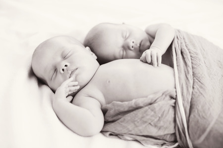 sweet twins are sleeping and hugging in soft focusの写真素材