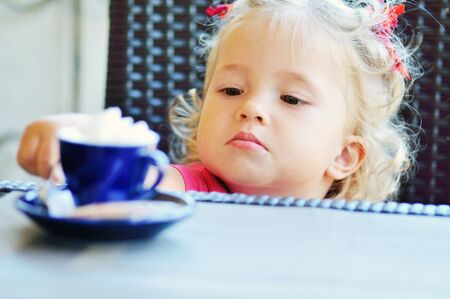 a funny toddler girl in the  cafeの写真素材