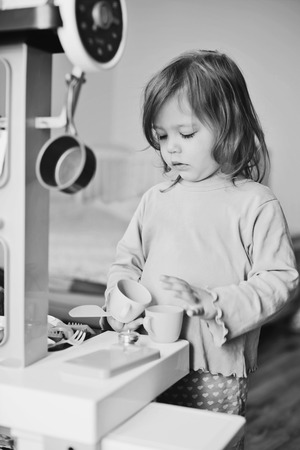 toddler girl playing with kitchen at homeの写真素材