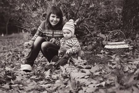 mother and baby son in fall having funの写真素材