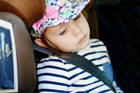 tired little girl in the car seatの写真素材