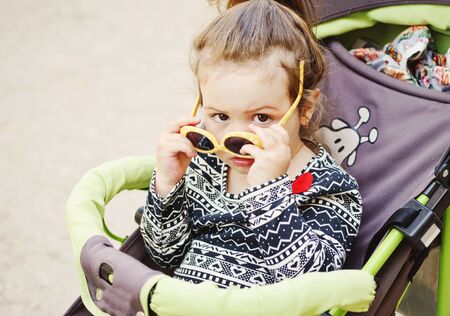 cute toddler girl sitting in the stroller