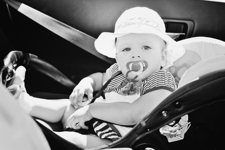 cute baby girl is sitting in car seat