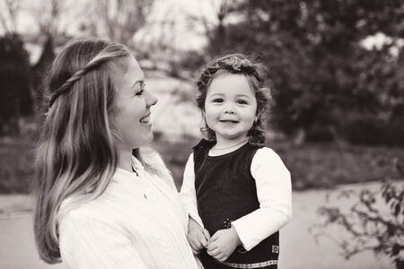 laughing mother and baby daughter in fall timeの写真素材