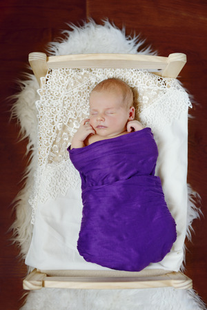 sweet newborn baby sleeping in the little bed