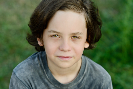 happy smiling preteen boy with long hairの写真素材