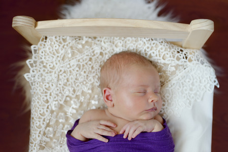 sweet newborn baby sleeping in the little bedの写真素材