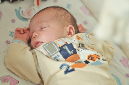 sweet three days old newborn sleeping in the crib