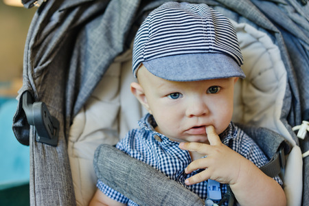 baby boy sitting in  the gray strollerの写真素材