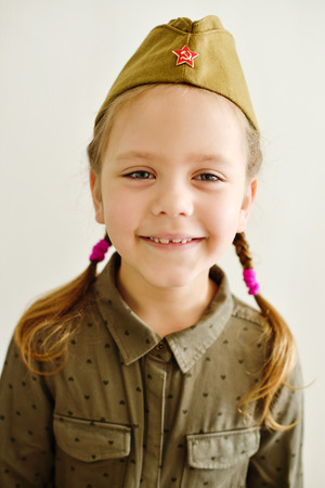 Portrait of a little girl wearing military uniform