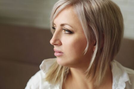 portrait of pensive woman with blonde hairの写真素材