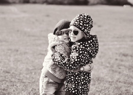 two little girls are hugging in spring fieldの写真素材