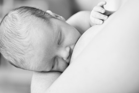 mother feeding her sweet newborn with breastの写真素材