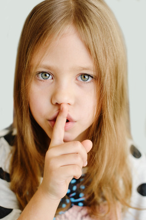 girl placing finger on lips asking shh, quiet, silenceの写真素材