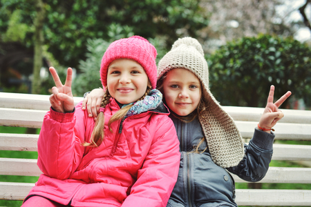 two funny happy girls on the benchの写真素材
