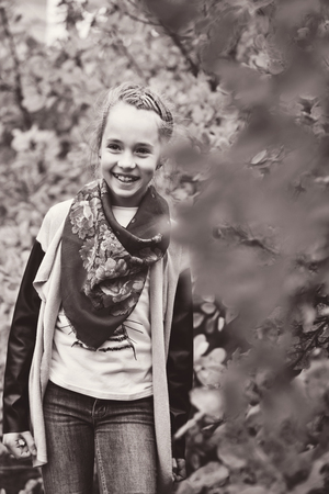 happy preteen girl  is standing near the fall bushesの写真素材