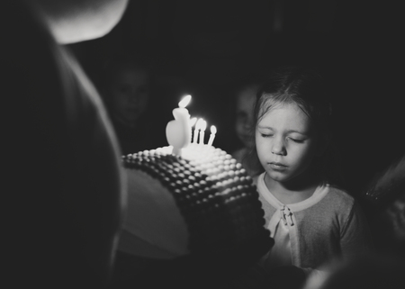 girl with birthday cake with caldles wishing in darknessの写真素材