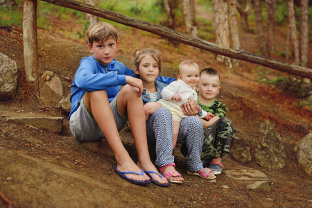 children in the forest sitting on the stonesの写真素材
