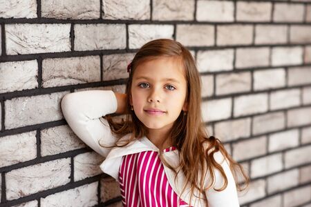 portrait of cute little girl near the wall