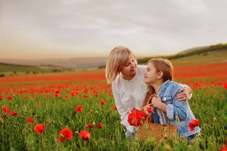 happy mother and daughter in the poppy fieldの写真素材