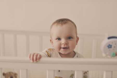 sweet and funny baby standing in the bed