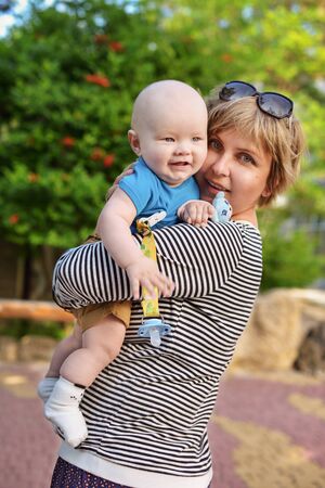 happy mother with baby son outdoor in springの写真素材
