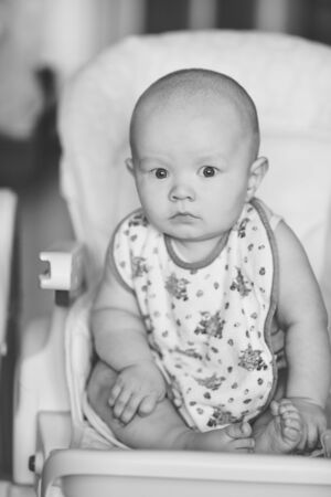 funny and surprised baby trying to seatの写真素材