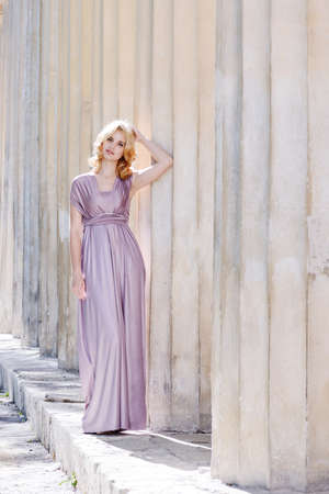 beautiful girl wearing long dress near the columnsの写真素材