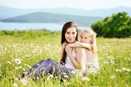 woman and girl in field of daisiesの写真素材