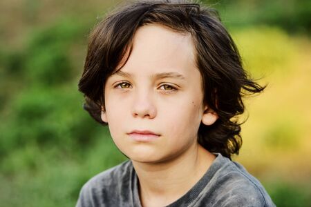 portrait of thoughtful preteen boy with long hairの写真素材