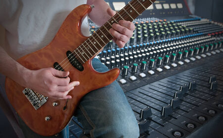 Man playing electric guitar in studioの写真素材