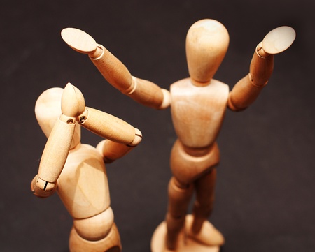 Two wooden figures standing and clapping in handsの写真素材