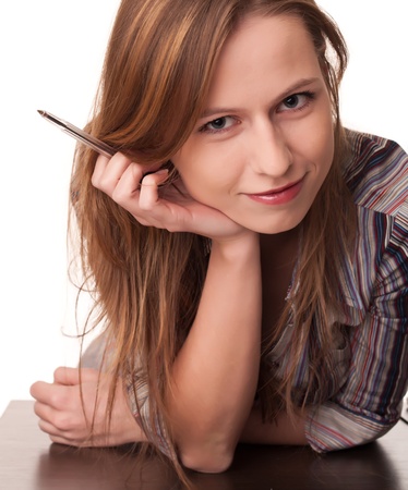 Joyful young woman leaning at table and smiling on white backgroundの写真素材