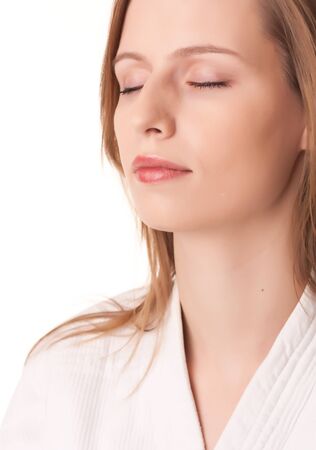 Young woman sitting in white kimono eyes closed meditatingの写真素材