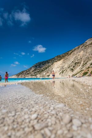 People relaxing at the Myrtos beach in Kefalonia, Greece.