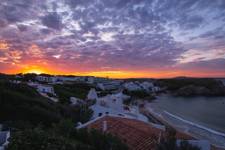 Stunning sunset over the bay of Arenal d'en Castell, Menorca. Vibrant colors reflected in the sea.の写真素材