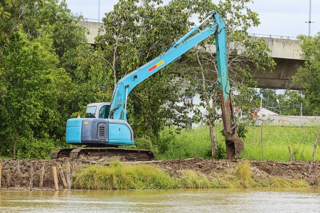 excavator loader machine during earthmoving works outdoors at construction siteの写真素材