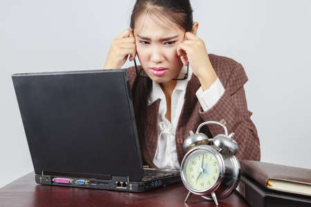 A depressed Asian businesswoman in her officeの写真素材