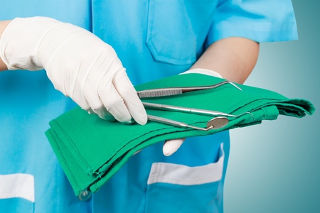 Closeup of dentist hand taking mirror from on of dental tools.の写真素材