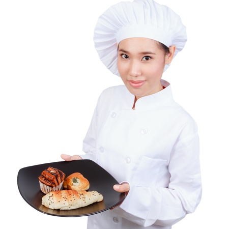 Smiling bakery chef holding a tray of fresh bakery. Isolated on white.の写真素材