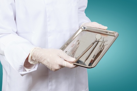 Closeup of dentist hand taking mirror from on of dental tools の写真素材