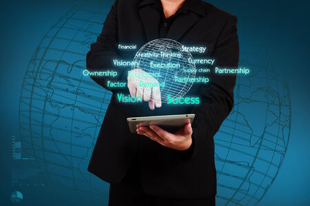 Businessman holding a tablet with virtual globe and business plan. Concept of business strategyの写真素材