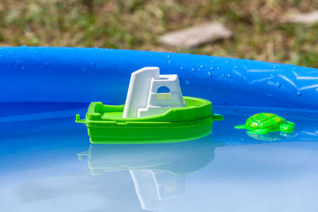 Toy sailboat and plastic turtle in a swimming poolの写真素材