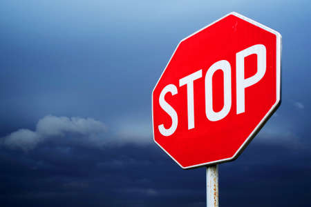 Conceptual stop sign with stormy background. Warning, caution and danger signの写真素材