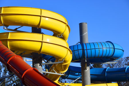 Colorful water slides on blue sky background, closeup of photo