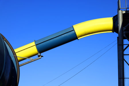 Blue and yellow pipe on blue sky background, closeup of photoの写真素材